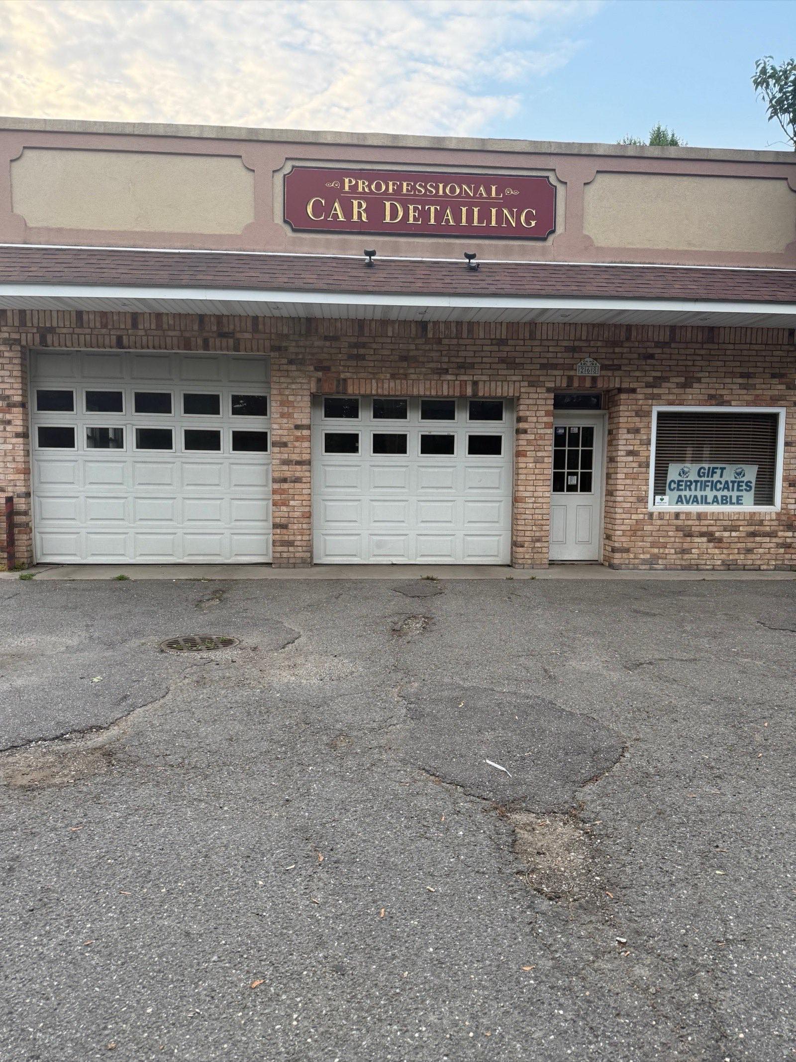 Red Ferrari Roma parked in front of Professional Car Detailing shop in Locust Valley